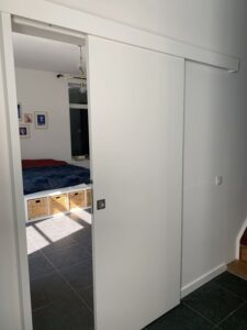 Porte coulissante blanche installée dans un intérieur.